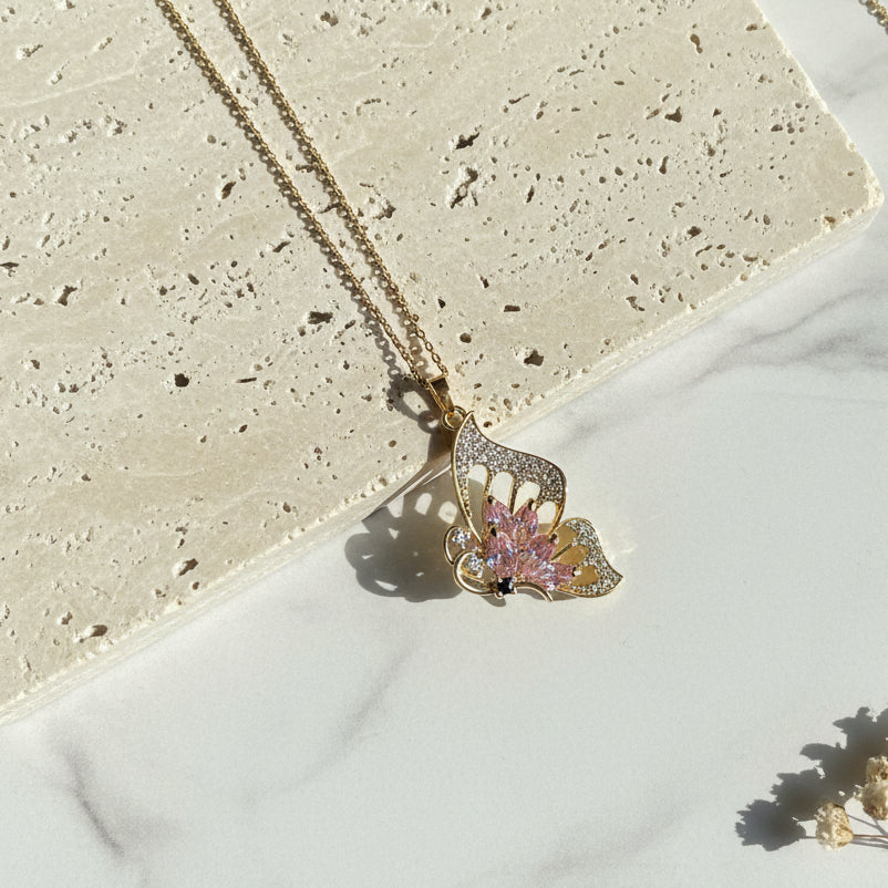 Close-up of the pink glass butterfly pendant — wing detail