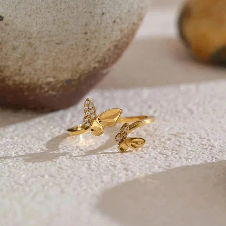 Gold butterfly ring on a textured surface