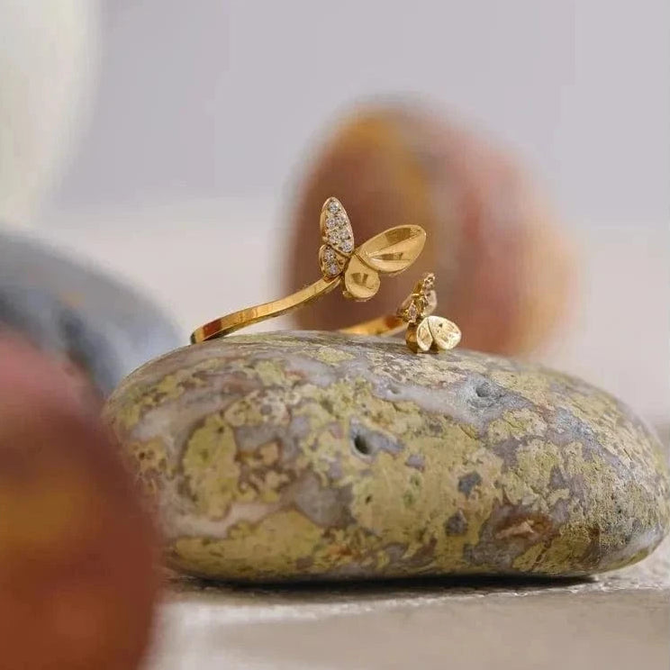 Gold ring with leaf design on a textured stone surface