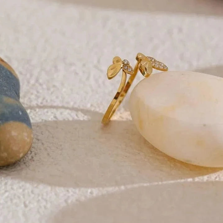 Gold ring with leaf design on a textured surface