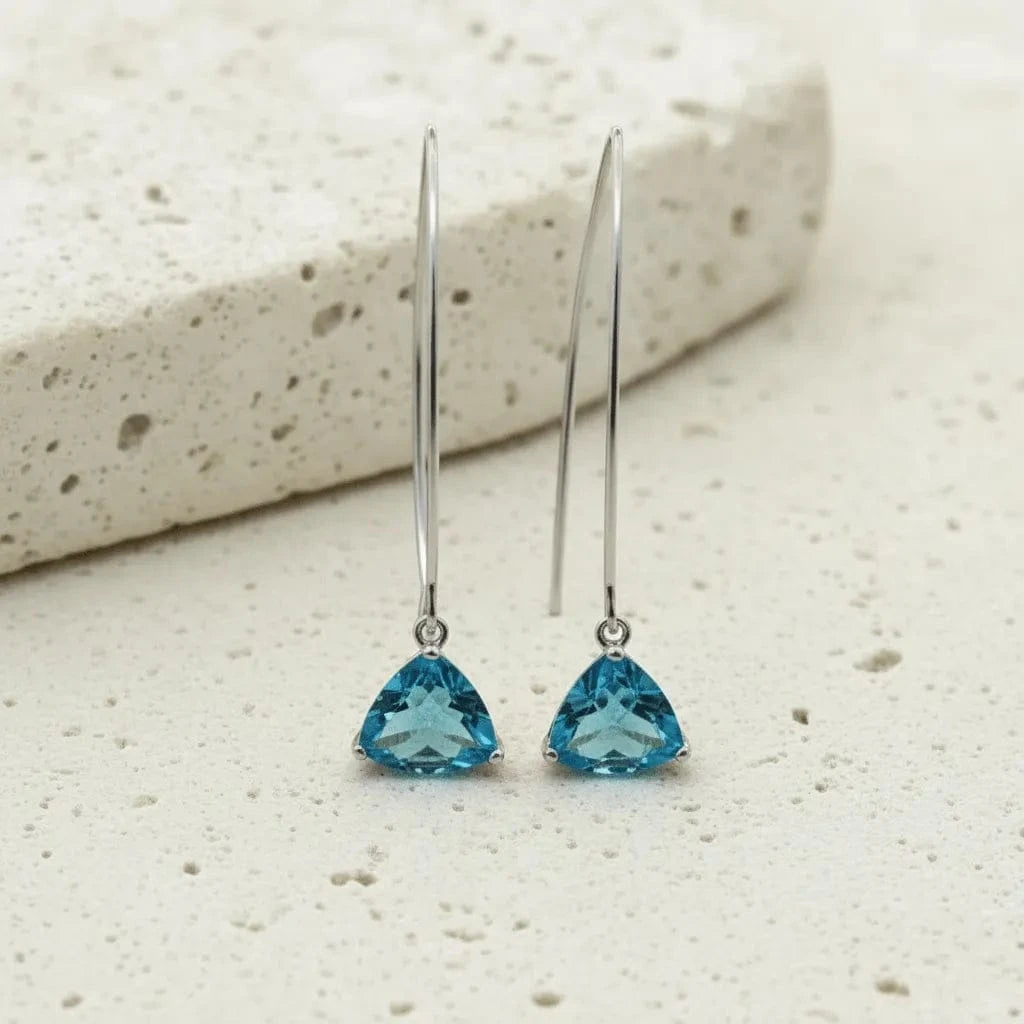 Pair of blue gemstone earrings on a light stone background