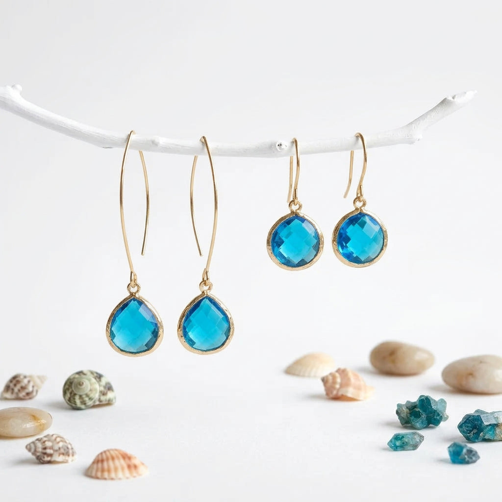Gold Capri blue glass pebble earrings on shepherd's hooks hanging from a branch