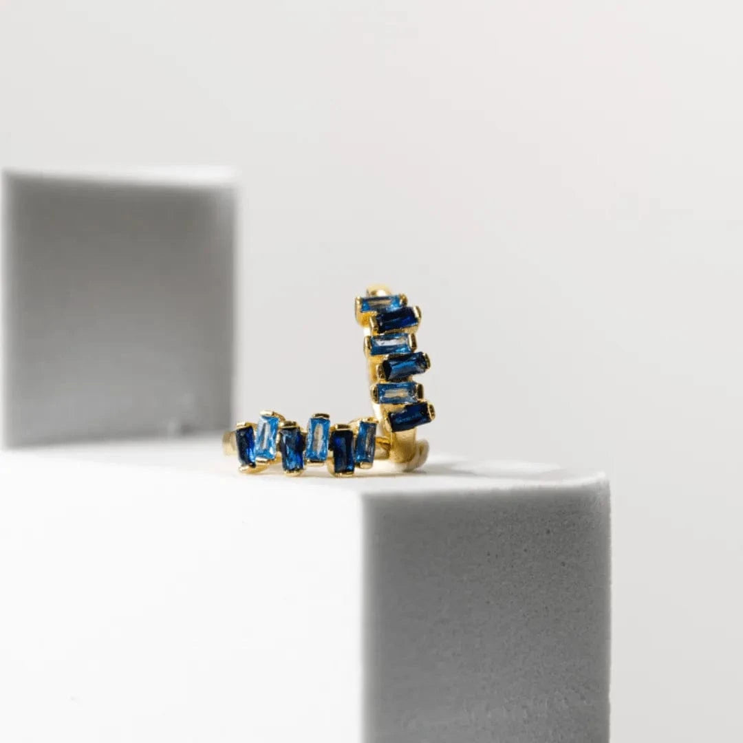 Gold ring with blue gemstones on a white background