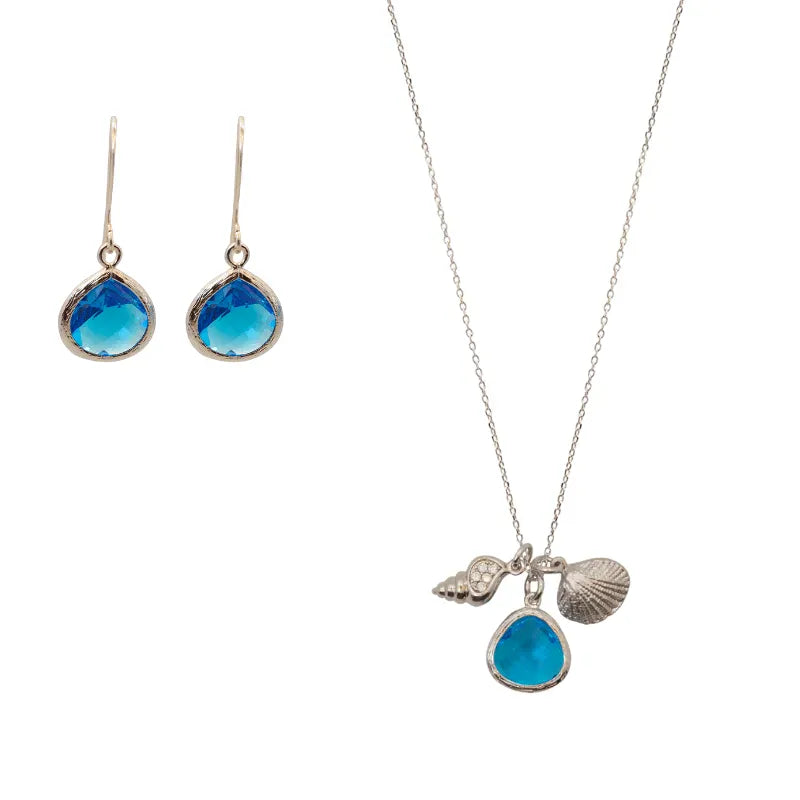 Jewelry set with blue teardrop pendants on a white background
