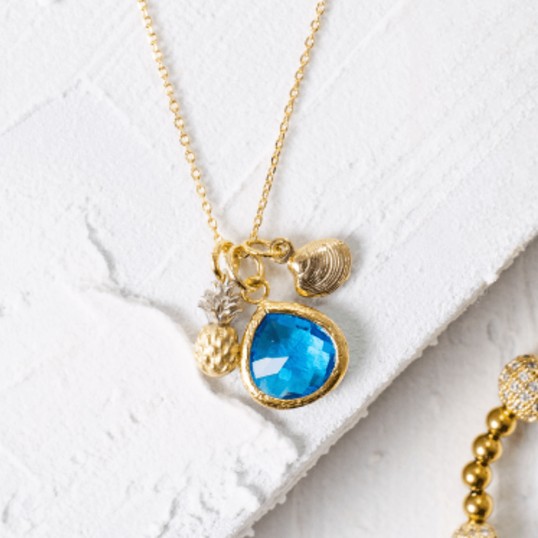 Necklace with blue pendant and gold accents on a white surface
