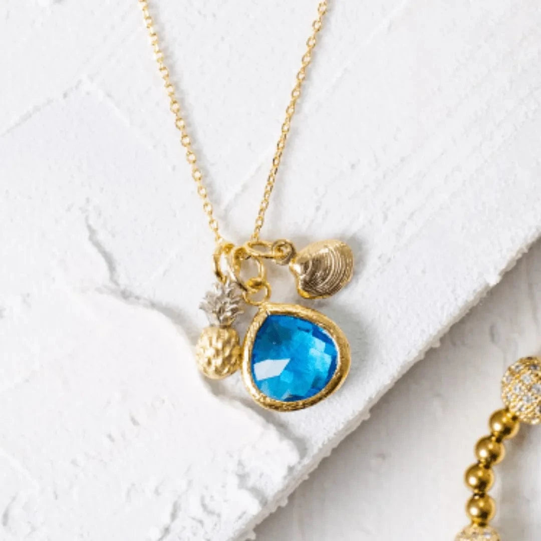 Necklace with blue pendant and gold accents on a white surface