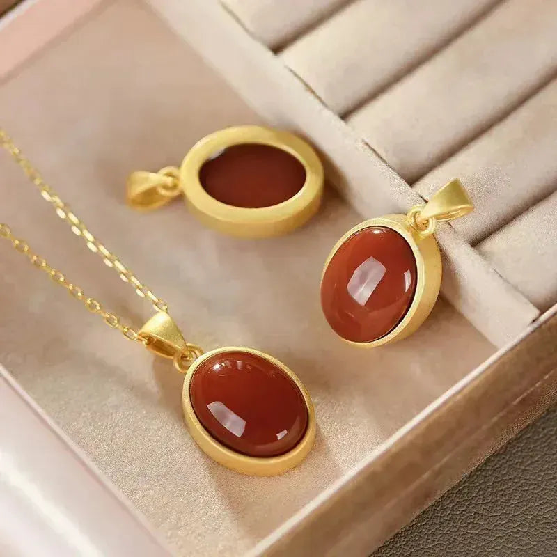 Gold necklaces with red stones on a beige jewelry box