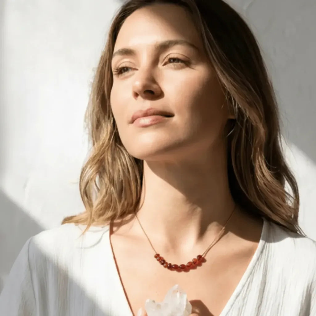 carnelian_necklace_gold Chakra_lifestyle Woman wearing a necklace with a white background