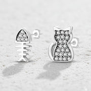 Cat-shaped silver earrings with embedded stones on a white background