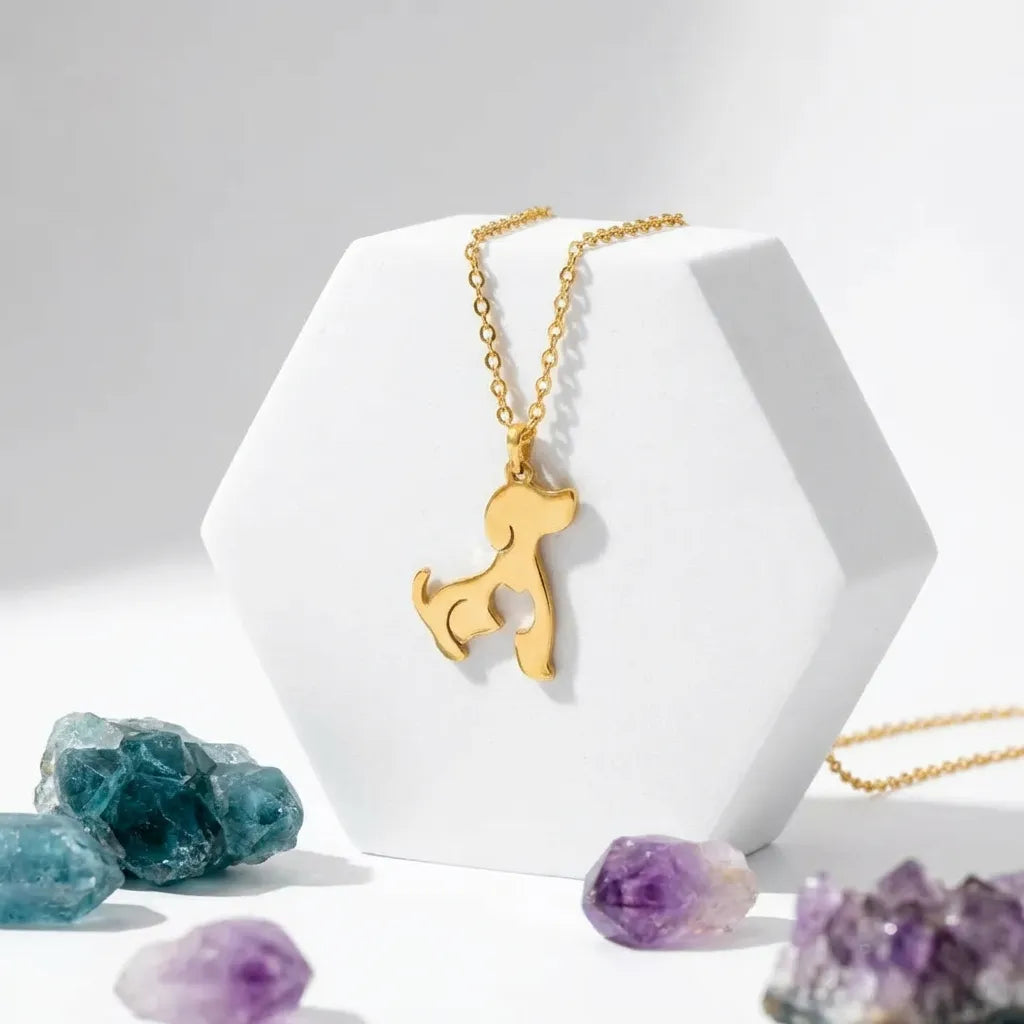Gold dog-shaped pendant necklace on a white stand with crystals in the background