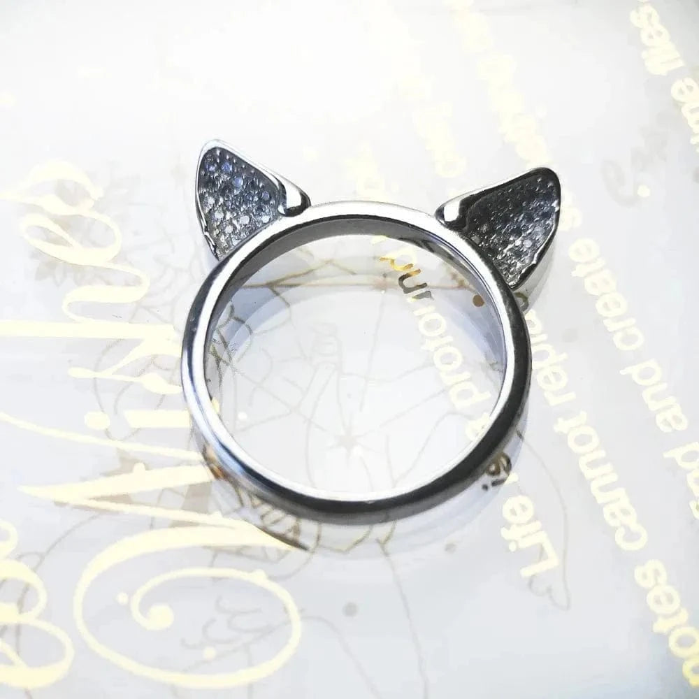 Silver ring with cat ears on a decorative surface
