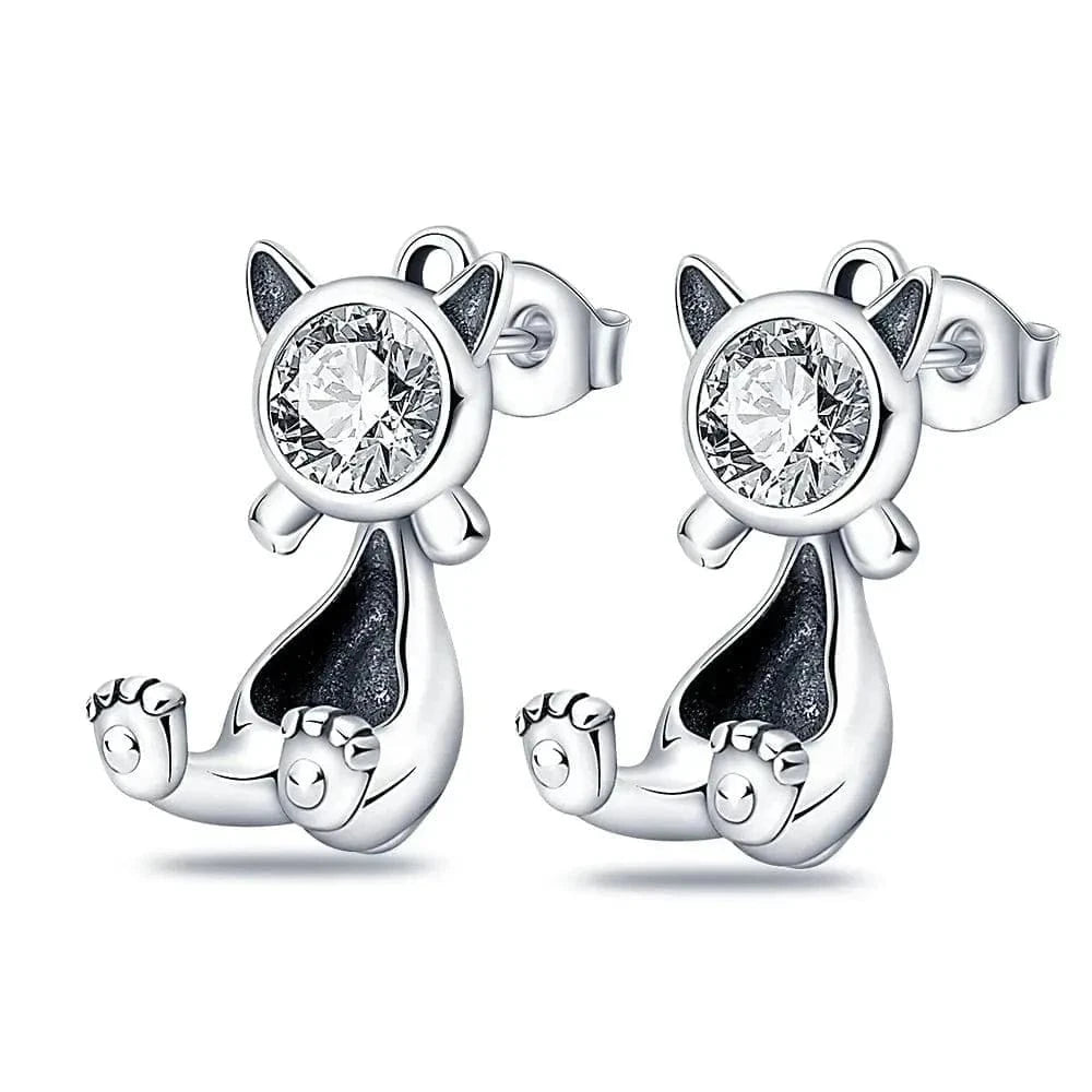 Cat-shaped silver earrings with clear gemstones on a white background