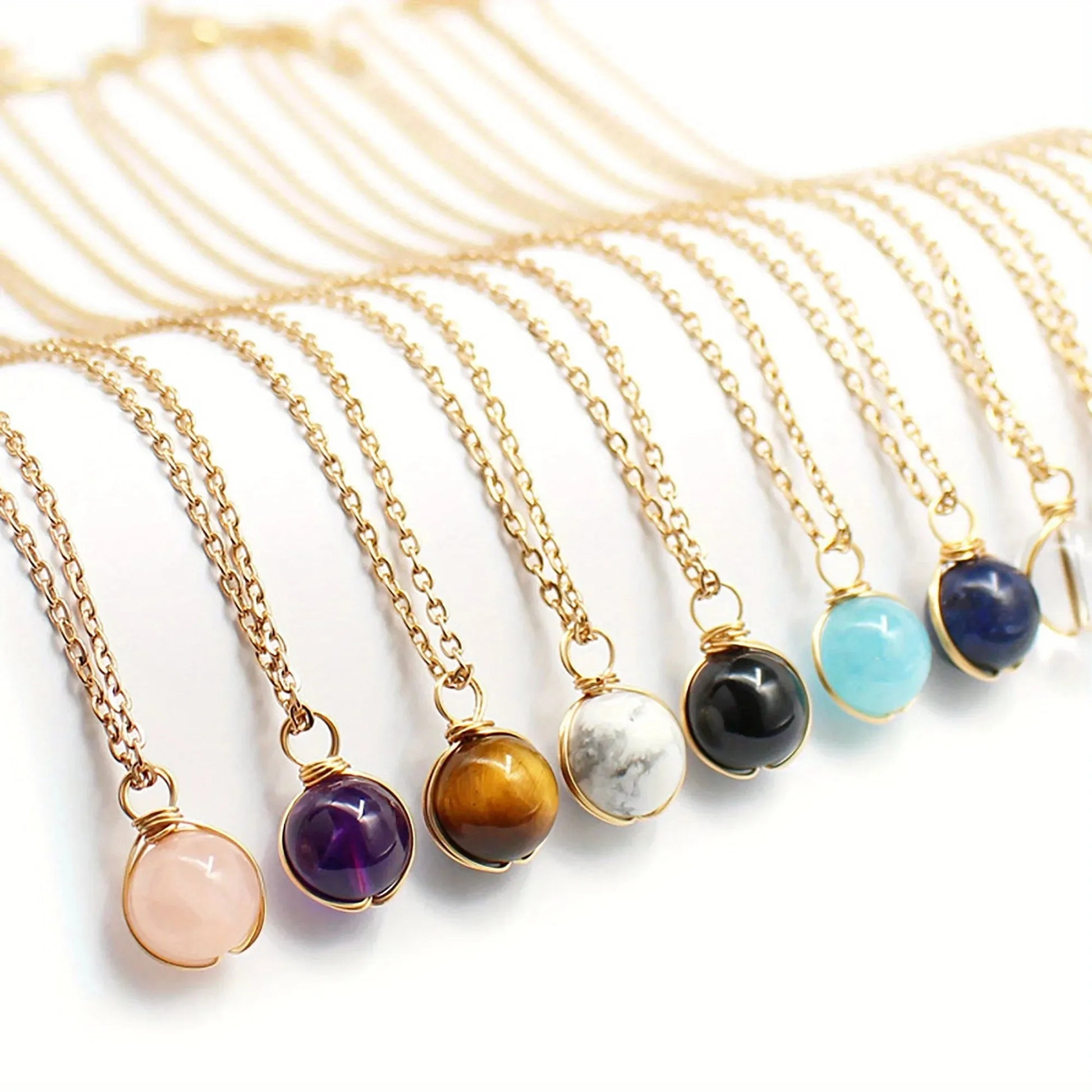 Gold necklaces with various colored gemstones on a white background