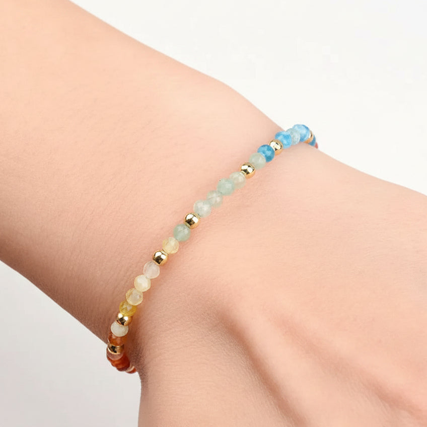 Beaded bracelet on a wrist with a pink background