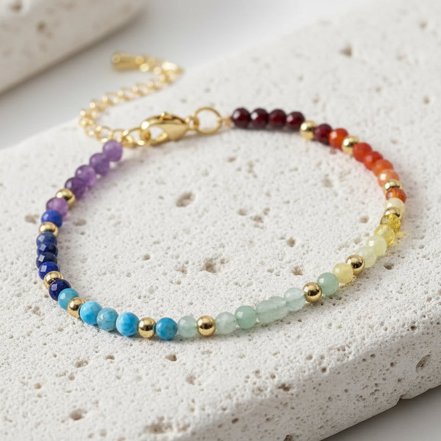 Multicolored beaded bracelet with gold accents on a white background