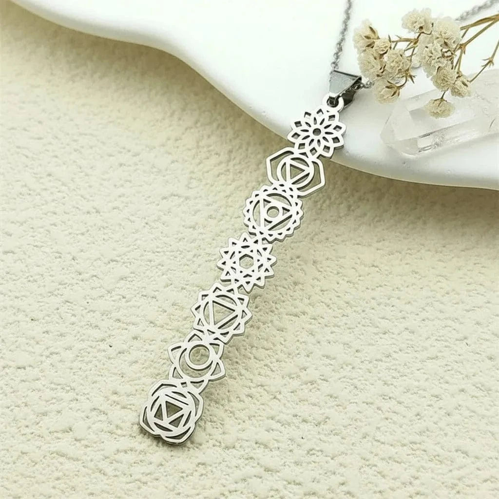 Silver necklace with geometric pendant on a textured beige surface