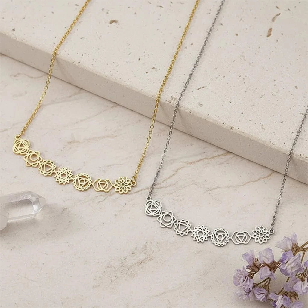 Two necklaces, one gold and one silver, on a dark surface