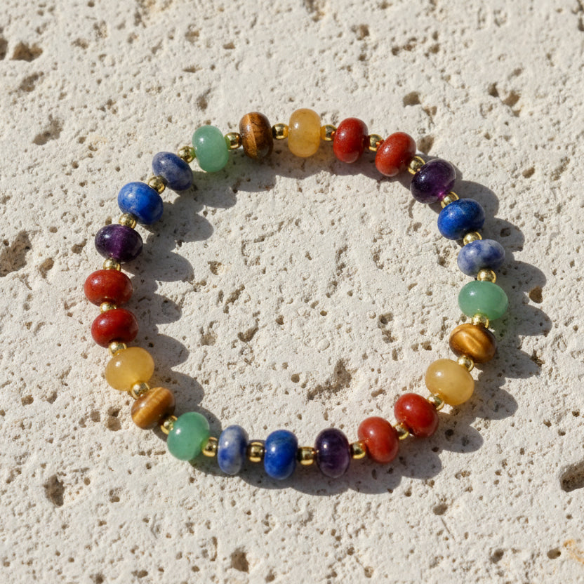 Multicolored beaded bracelet with gold accents on a white background