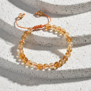 Citrine bracelet on a card with energy, confidence, positivity text on a wooden surface