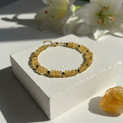 Faceted citrine and pyrite beaded bracelet resting on stone, November birthstone jewelry