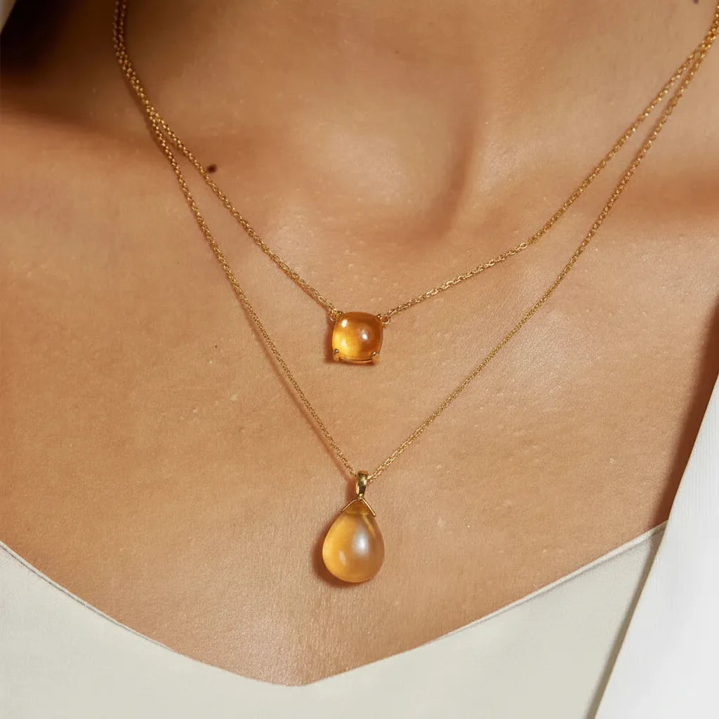 lifestyle image of woman wearing citrine and gold necklaces
