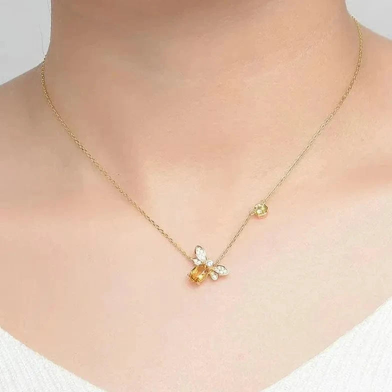 Gold necklace with a butterfly pendant worn by a person