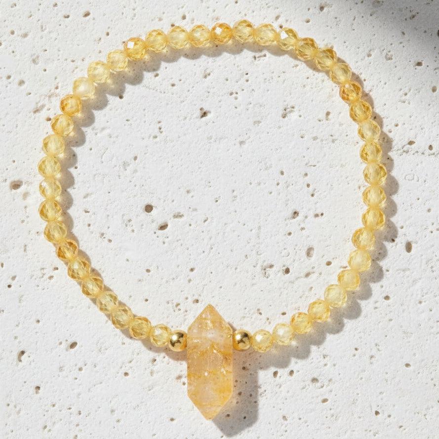 Yellow citrine beaded bracelet with a gold accent on a white background