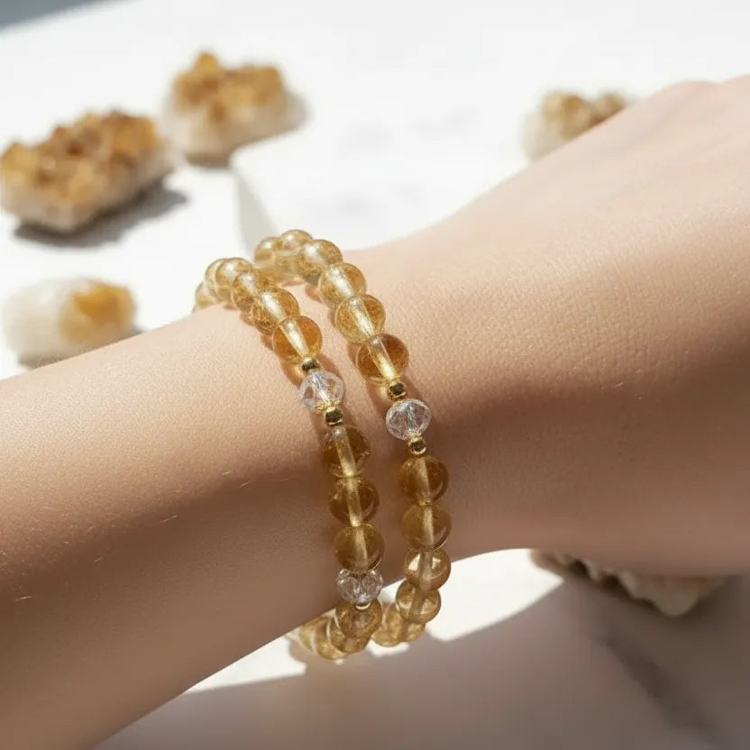 Hand wearing two beaded bracelets on a blurred background