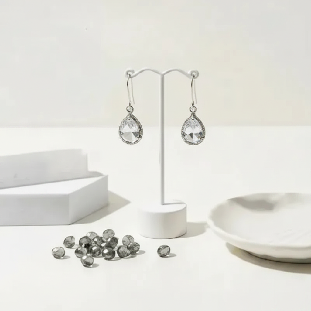 Clear exquisite teardrop earrings in silver on a display stand, April birthstone jewelry