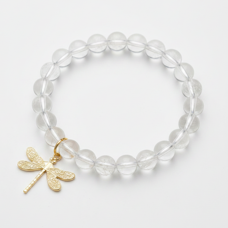 Clear quartz bracelet with a gold dragonfly charm — add-on symbol charm for transformation