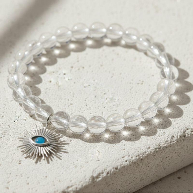 Clear quartz bracelet with a silver evil eye charm — add-on symbol charm for protection