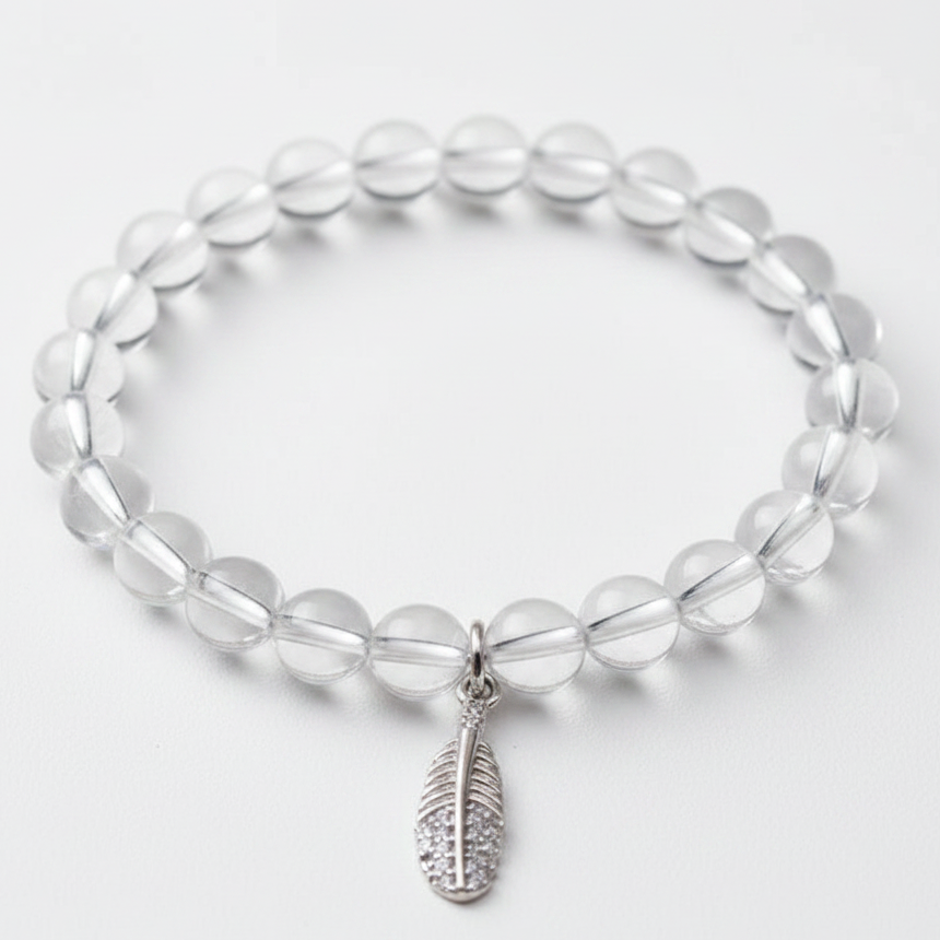 Clear quartz bracelet with a silver feather charm — add-on symbol charm for freedom