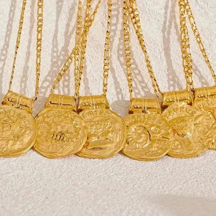 Gold necklaces with coins on a textured white background