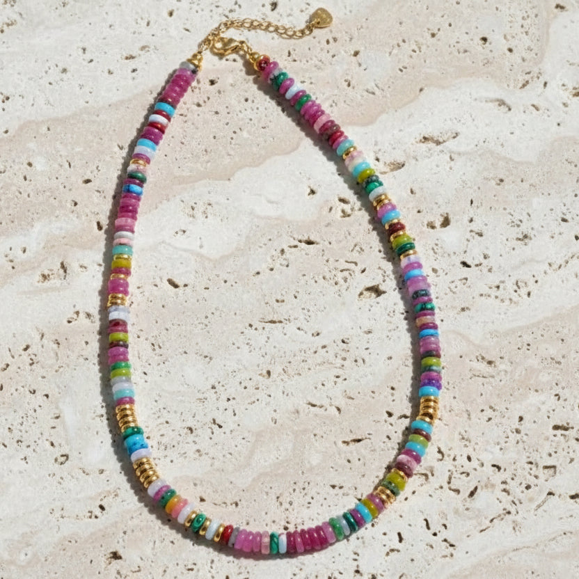 Colorful beaded necklace with a gold chain on a white background