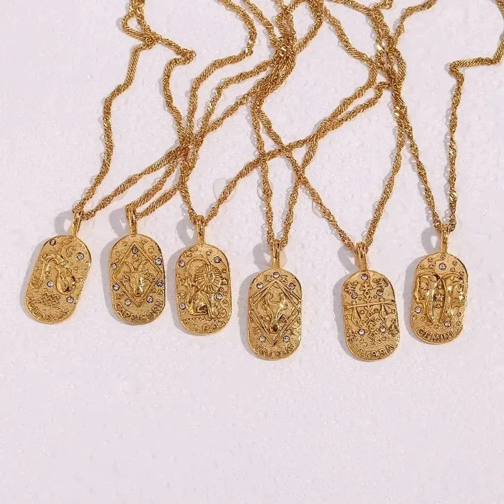 Gold necklaces with various pendants on a light pink background