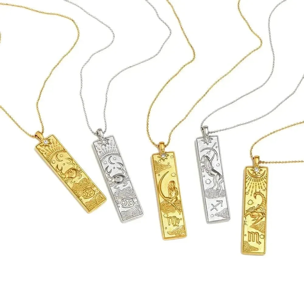 Four gold and silver necklaces with engraved designs on a white background