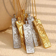 Gold and silver necklaces with intricate designs on a beige background