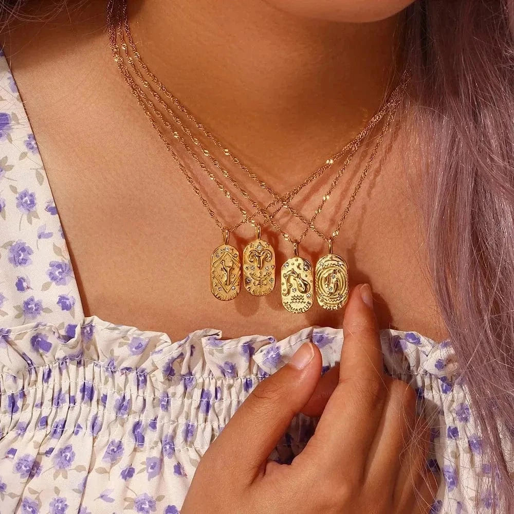 Close-up of a person wearing multiple gold necklaces with various pendants.