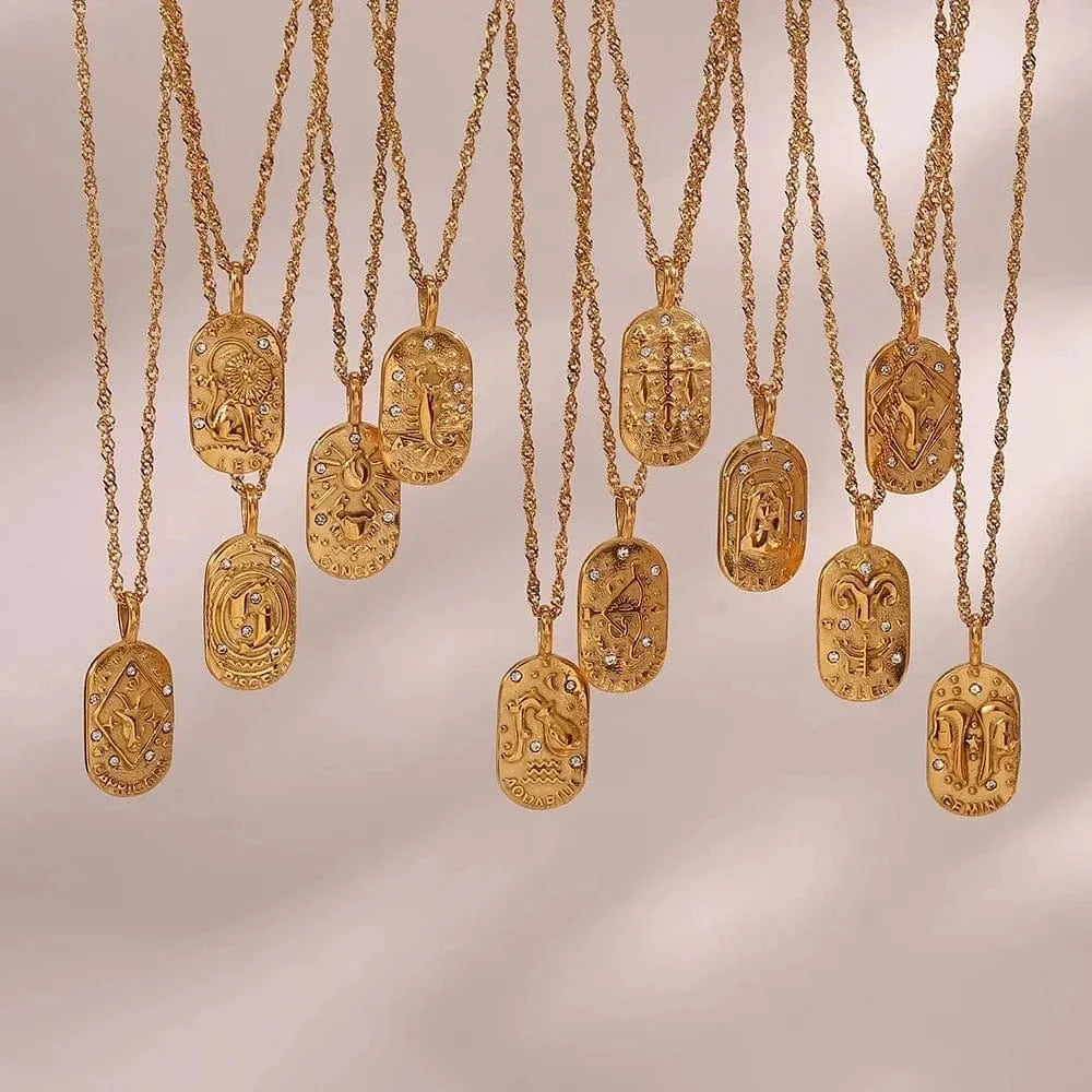 Gold necklaces with various pendants on a neutral background