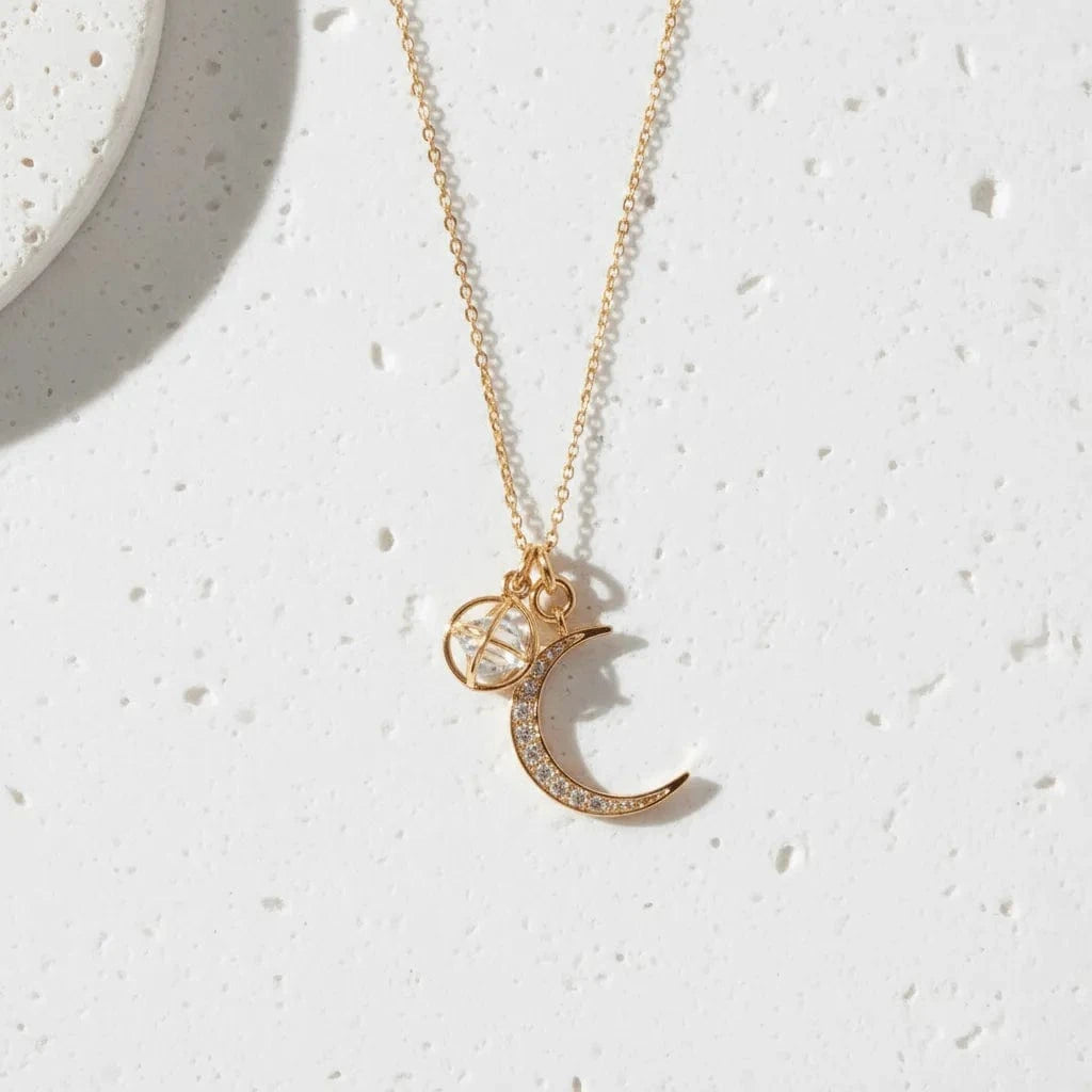Necklace with a crescent moon and gemstone pendant on a white background