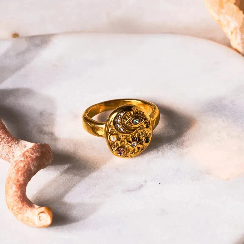 Gold ring with gemstones on a white shell