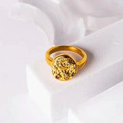 Gold ring with gemstones on a white fabric background