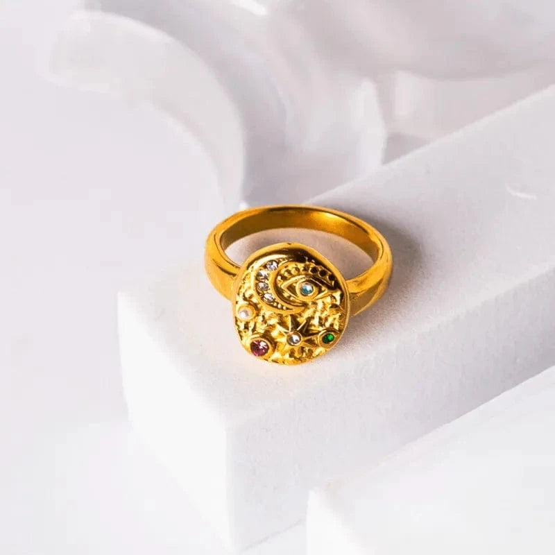 Gold ring with gemstones on a white fabric background