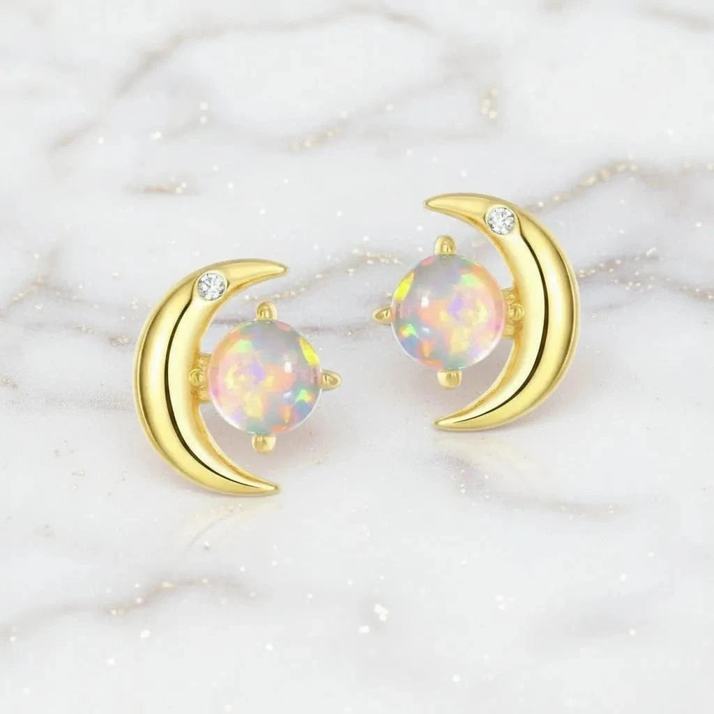Gold moon-shaped earrings with opal stones on a white background,