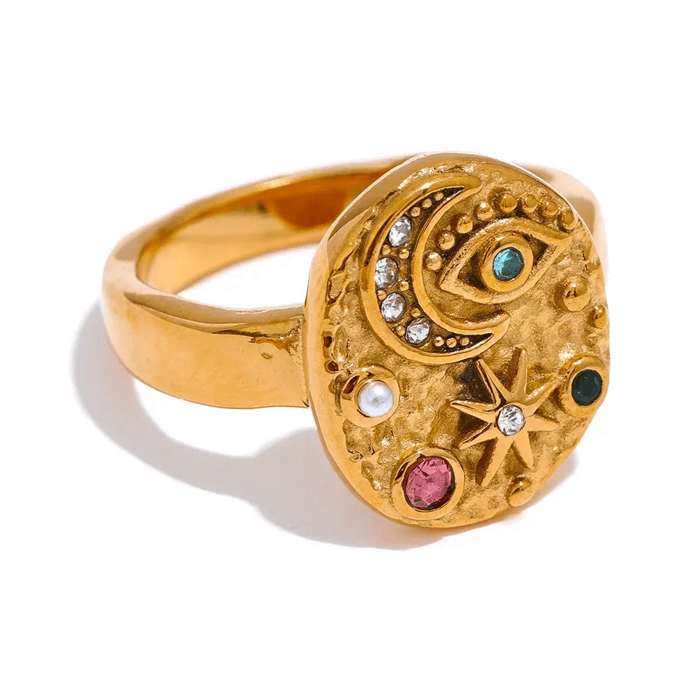 Gold ring with celestial design on a white background