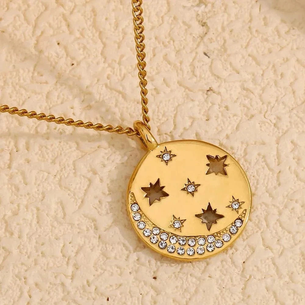 Gold necklace with star-shaped pendant on a textured beige background