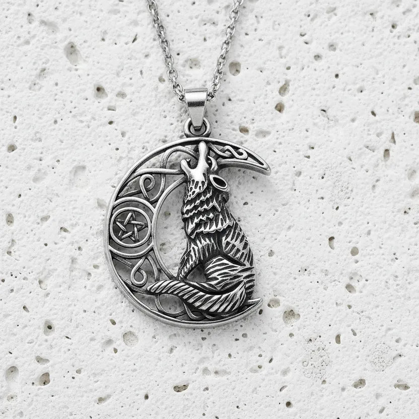 Silver pendant with a wolf design on a textured white surface