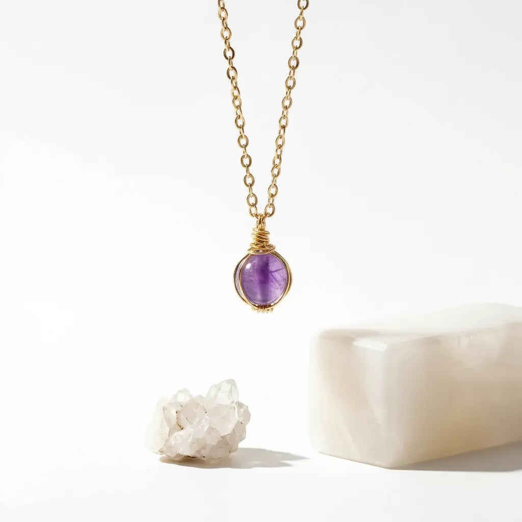 Gold necklace with a amethyst purple gemstone pendant on a white background