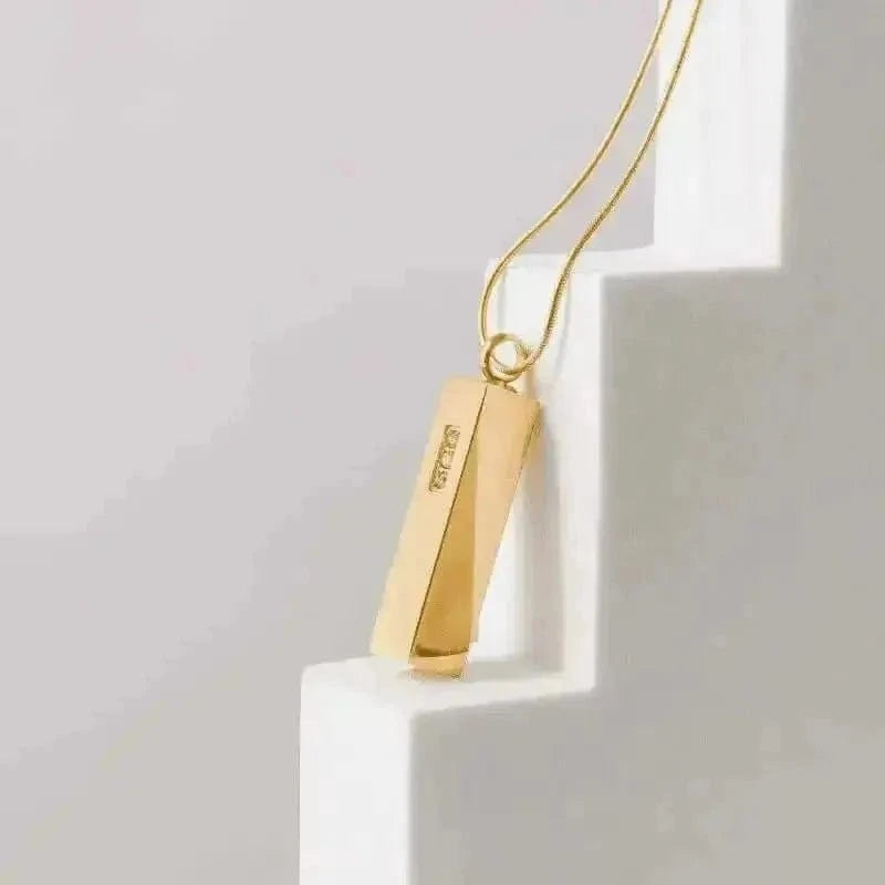 Gold pendant necklace on a white surface