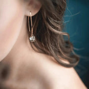 Woman wearing aurora crystal ball drop earring in gold